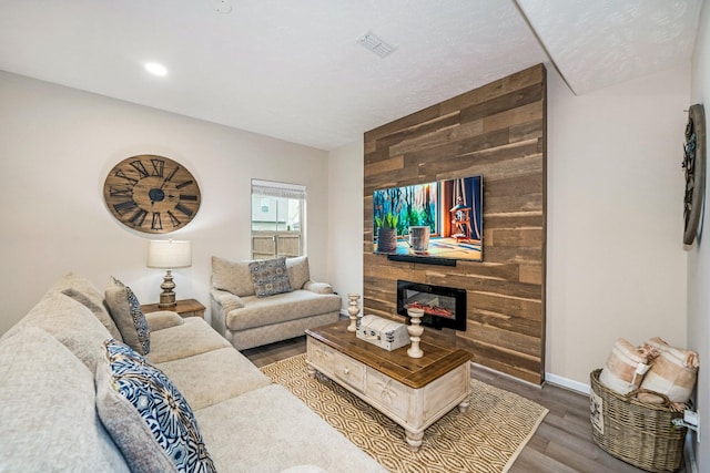 living area featuring wood finished floors, visible vents, and baseboards