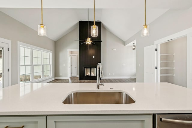 kitchen featuring open floor plan, pendant lighting, a ceiling fan, and a sink