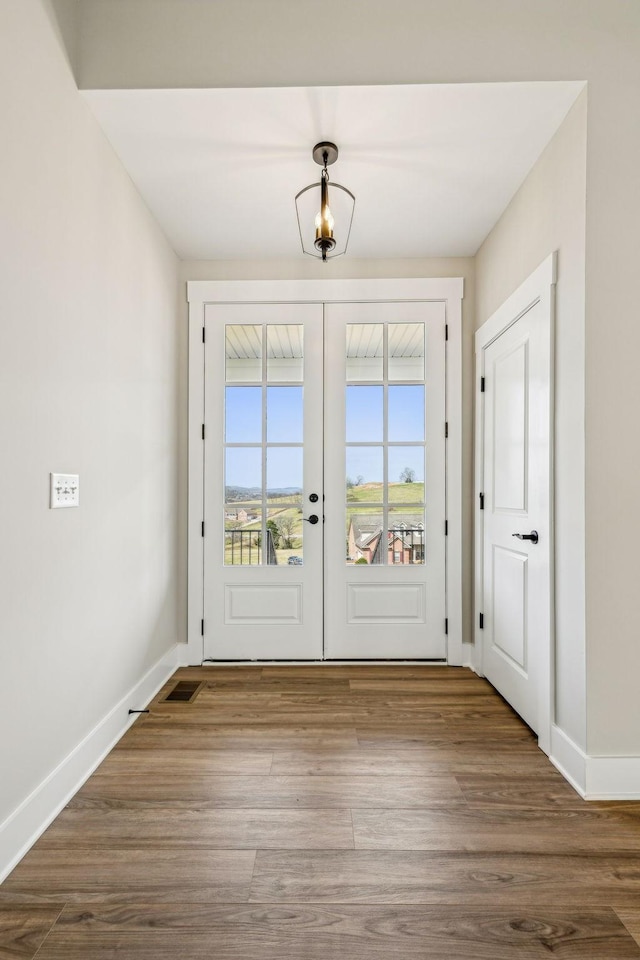 doorway to outside with wood finished floors, visible vents, french doors, and baseboards