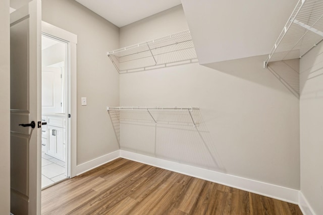 walk in closet with wood finished floors