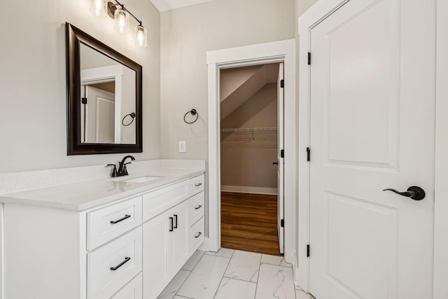 bathroom featuring vanity, baseboards, and marble finish floor