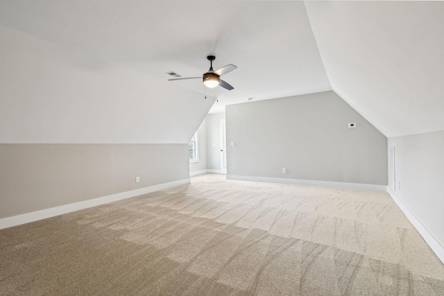 bonus room with baseboards, light colored carpet, visible vents, and ceiling fan