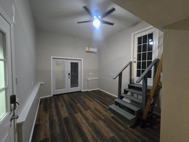 foyer with stairs, a wall unit AC, french doors, wood finished floors, and a ceiling fan