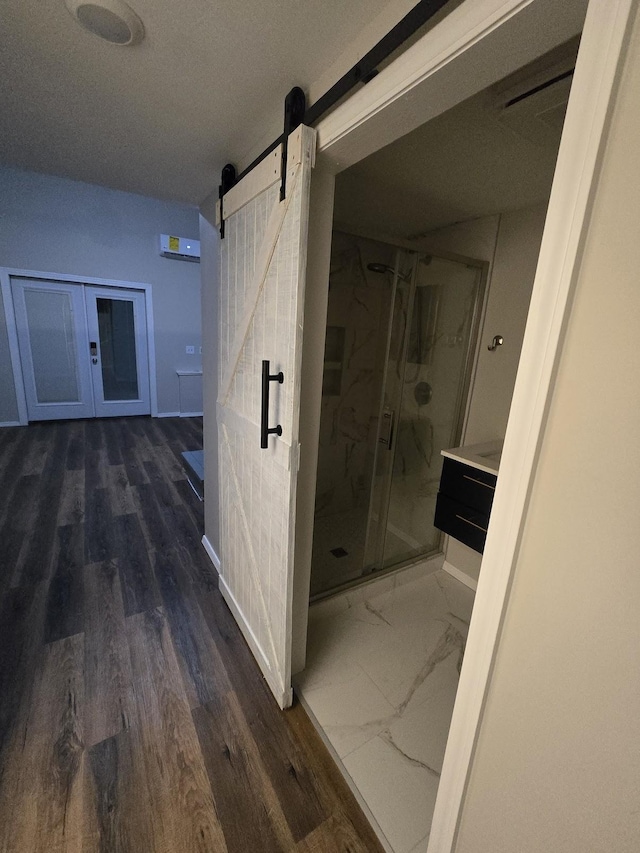 hallway featuring a barn door and marble finish floor