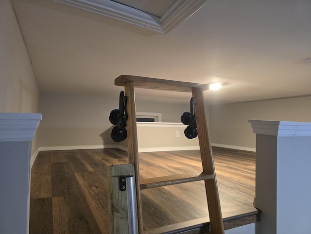 workout room featuring vaulted ceiling, wood finished floors, and baseboards