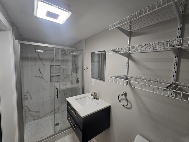 bathroom with a marble finish shower, toilet, and vanity