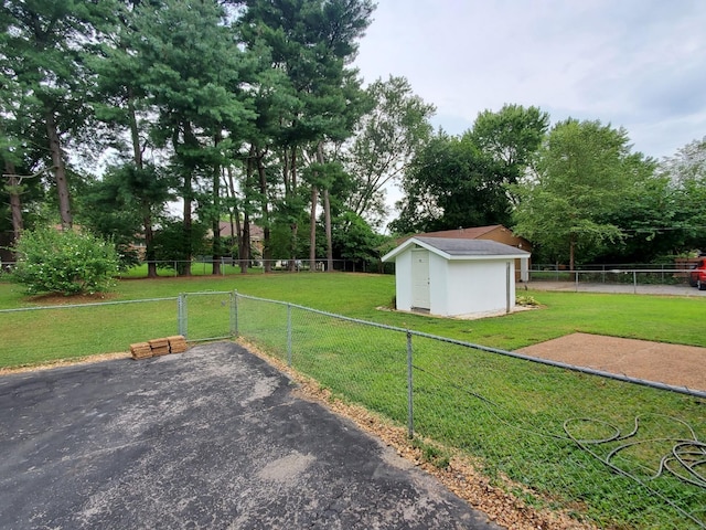 view of yard with a gate, a shed, an outdoor structure, and fence