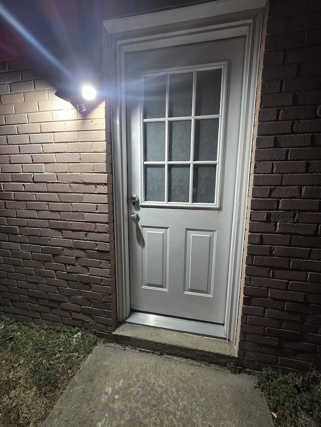 entrance to property featuring brick siding