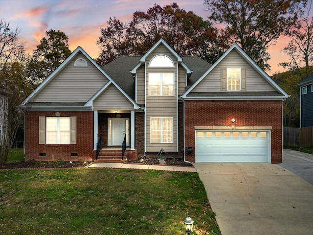traditional-style house featuring brick siding, a garage, crawl space, concrete driveway, and a yard
