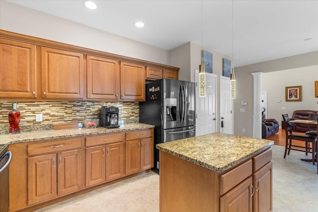 kitchen with decorative backsplash, a kitchen island, black fridge with ice dispenser, brown cabinets, and light stone counters