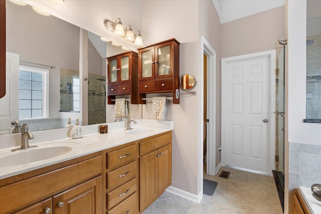 bathroom with a sink, tile patterned floors, a stall shower, and double vanity