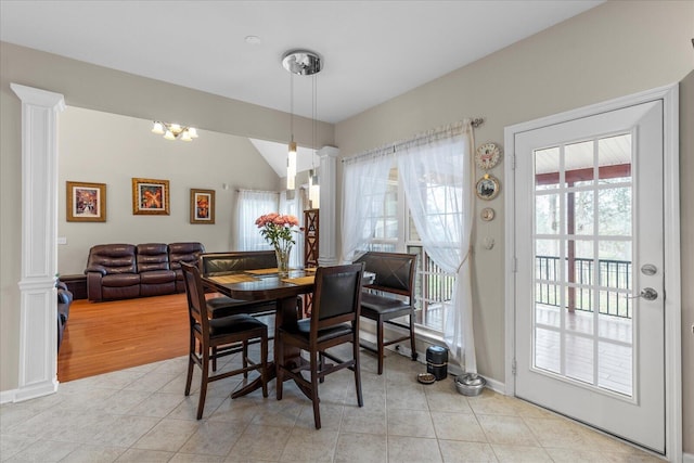 dining room featuring light tile patterned floors, decorative columns, and lofted ceiling