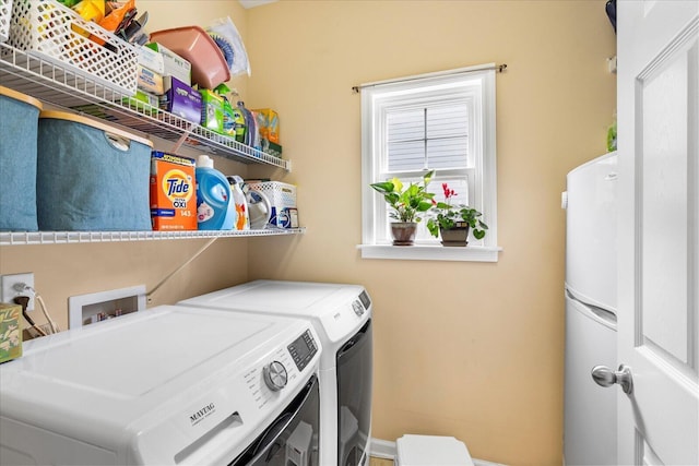 clothes washing area with separate washer and dryer and laundry area