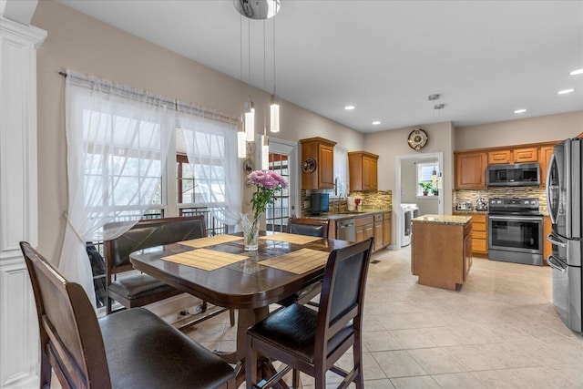 dining space with light tile patterned floors, recessed lighting, and washing machine and clothes dryer