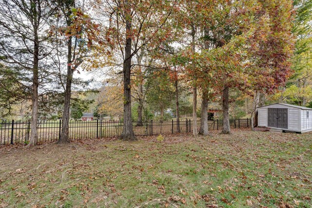 view of yard featuring a fenced backyard, an outbuilding, and a storage shed
