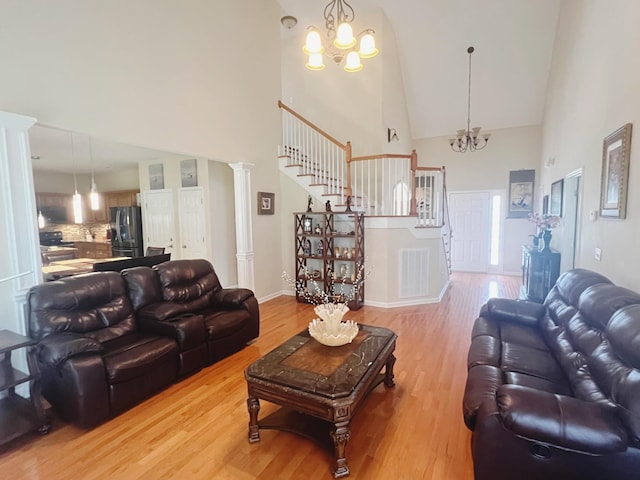 7087 Neville Dr, Ooltewah, TN 37363 - living room featuring high vaulted ceiling, a chandelier, light wood-style floors, and stairway