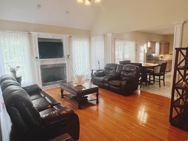 7087 Neville Dr, Ooltewah, TN 37363 - living room with healthy amount of natural light, light wood-type flooring, a fireplace with raised hearth, and high vaulted ceiling