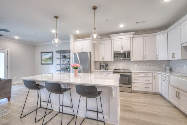 kitchen with a center island, visible vents, stainless steel appliances, and decorative backsplash