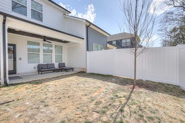 view of yard featuring an outdoor living space, a patio area, a fenced backyard, and ceiling fan