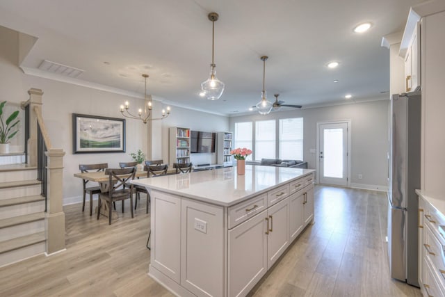 kitchen featuring light countertops, open floor plan, freestanding refrigerator, and light wood-type flooring