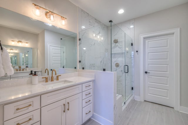 bathroom featuring vanity, baseboards, and a marble finish shower