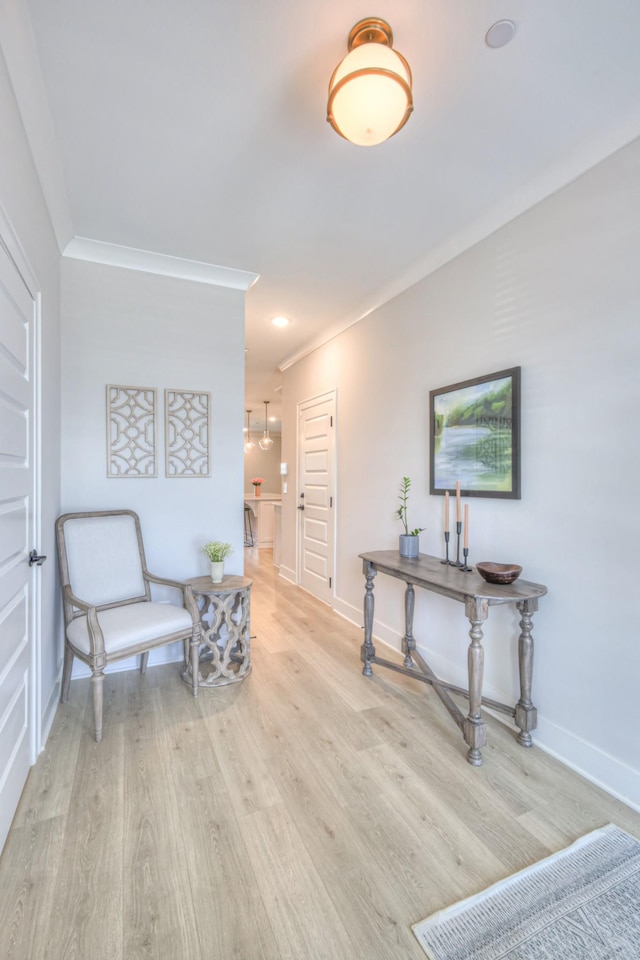 living area with crown molding, baseboards, and wood finished floors