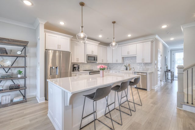 kitchen featuring decorative backsplash, white cabinetry, stainless steel appliances, and ornamental molding