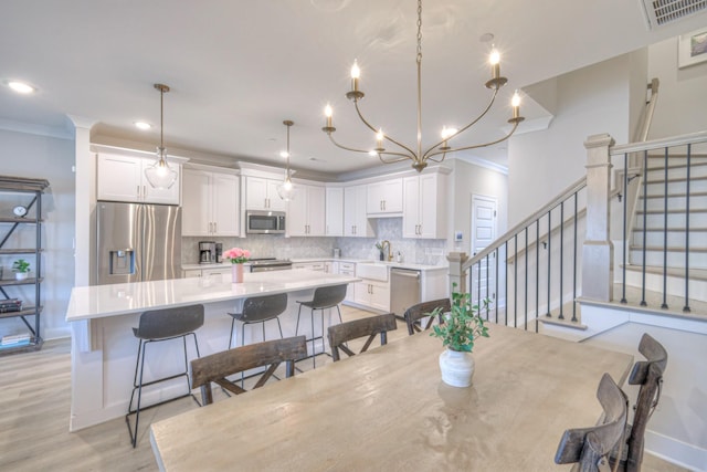 dining area with stairs, crown molding, light wood-style flooring, and baseboards