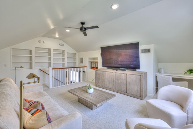 living area featuring visible vents, built in shelves, ceiling fan, vaulted ceiling, and carpet flooring