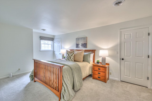 bedroom with baseboards, visible vents, and light carpet