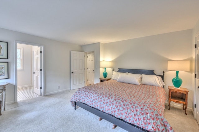 bedroom featuring baseboards and light colored carpet