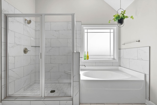 bathroom featuring a stall shower, a garden tub, and vaulted ceiling