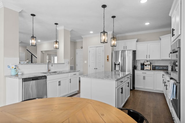 kitchen with dark wood-style flooring, a sink, stainless steel appliances, white cabinetry, and a center island