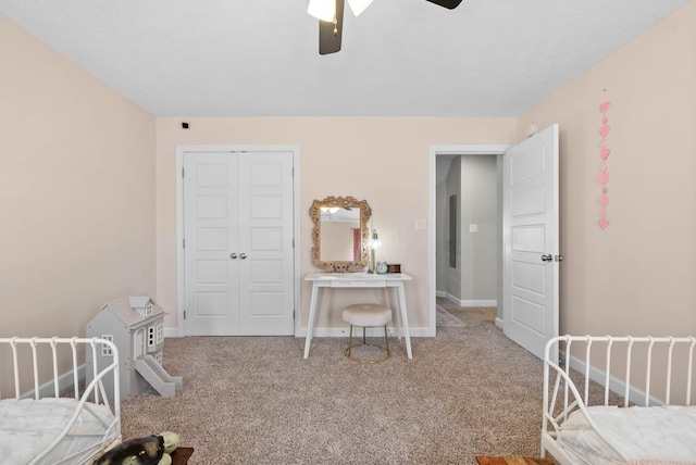 bedroom with a closet, baseboards, carpet, and ceiling fan