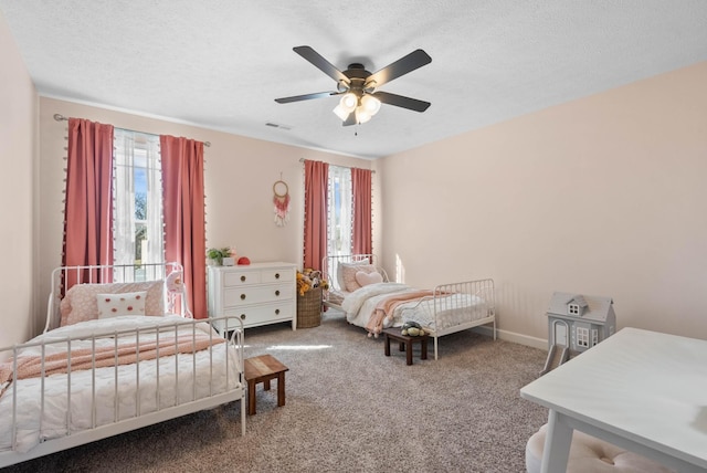 bedroom with visible vents, baseboards, carpet flooring, a textured ceiling, and a ceiling fan