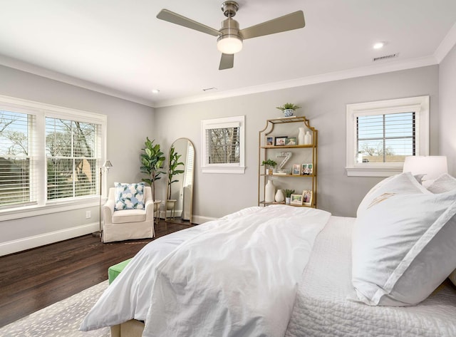 bedroom featuring crown molding, wood finished floors, visible vents, and baseboards