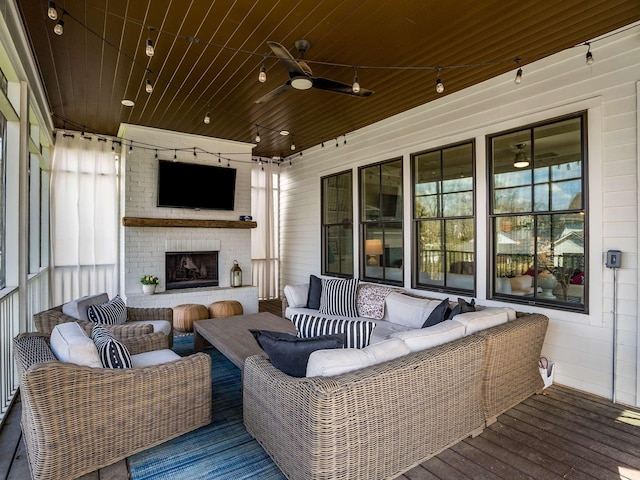 wooden deck with an outdoor living space with a fireplace and a ceiling fan