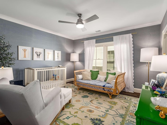 living area featuring crown molding, a ceiling fan, visible vents, and baseboards