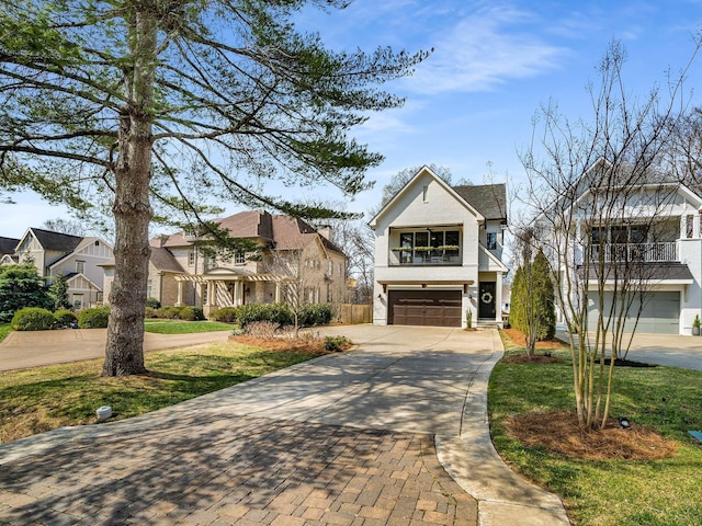 view of front of house featuring a front yard, an attached garage, a residential view, and driveway