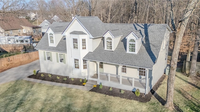 cape cod house with driveway, a porch, fence, roof with shingles, and a front yard