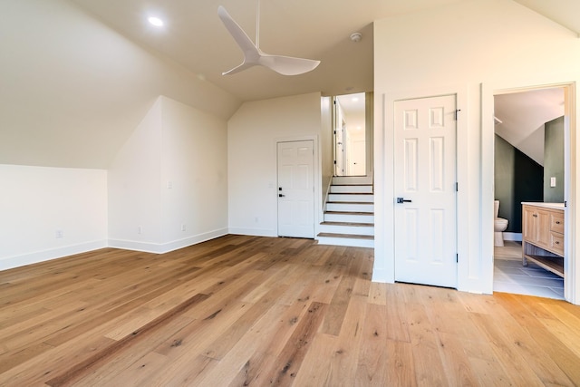 bonus room featuring ceiling fan, baseboards, stairs, light wood-type flooring, and lofted ceiling