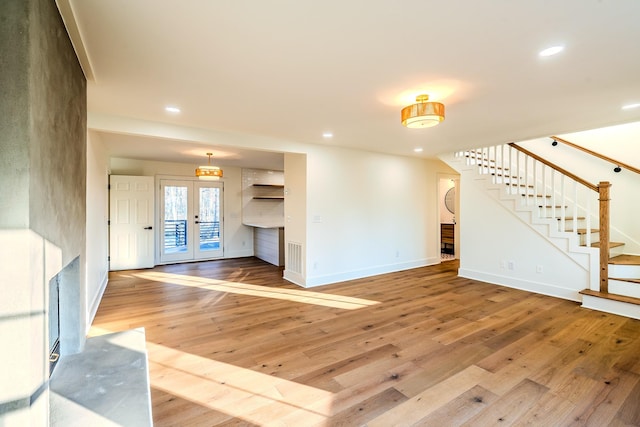 unfurnished living room featuring stairway, recessed lighting, light wood-type flooring, and baseboards