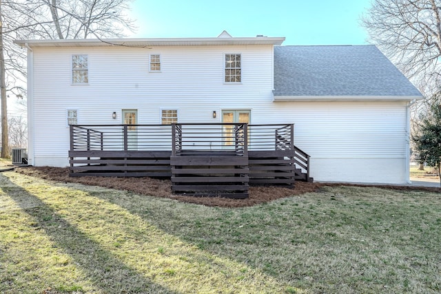 rear view of property featuring a yard, central AC unit, roof with shingles, and a deck