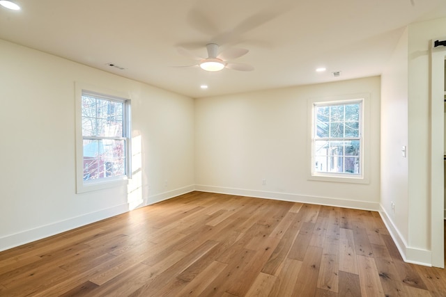 spare room with plenty of natural light, light wood-style floors, and a ceiling fan