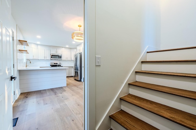 staircase with recessed lighting and wood finished floors