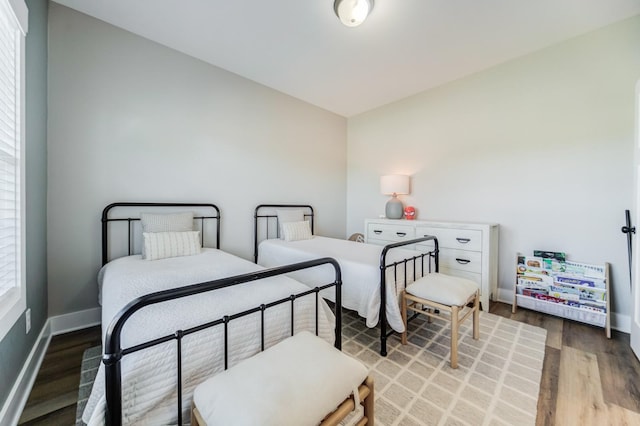 bedroom with baseboards and wood finished floors