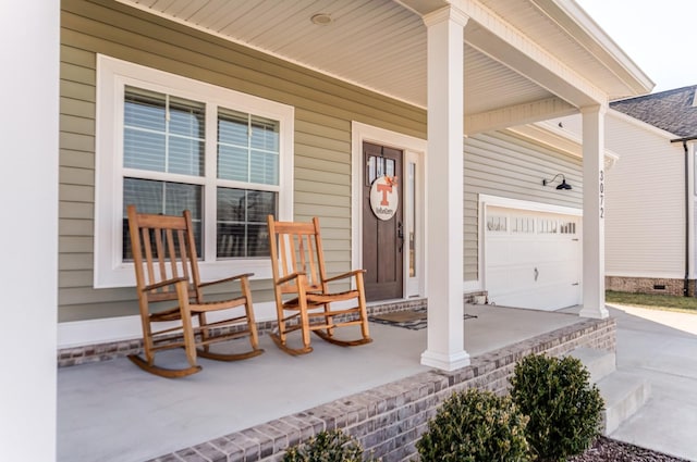 doorway to property with an attached garage, a porch, and driveway