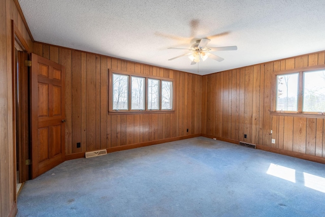 unfurnished room featuring visible vents, carpet floors, and ceiling fan
