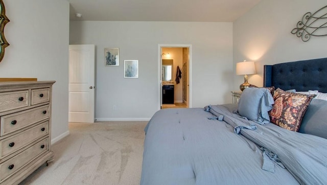 bedroom with light carpet, connected bathroom, and baseboards