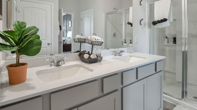 full bath featuring double vanity, a stall shower, and a sink